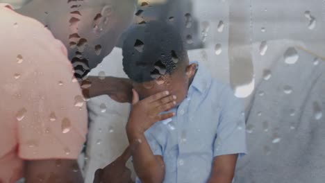 Animation-Von-Regentropfen-über-Einem-Afroamerikanischen-Vater,-Der-Seinen-Weinenden-Sohn-Anschreit