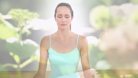 Animation-Von-Blumen-über-Einer-Kaukasischen-Frau,-Die-Yoga-Praktiziert-Und-Meditiert