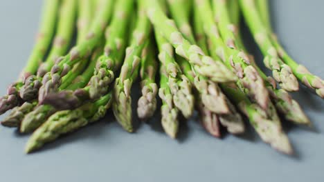 Video-of-close-up-of-fresh-asparagus-over-grey-background