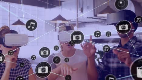 Animation-of-network-of-connections-with-icons-over-diverse-business-people-using-vr-headsets