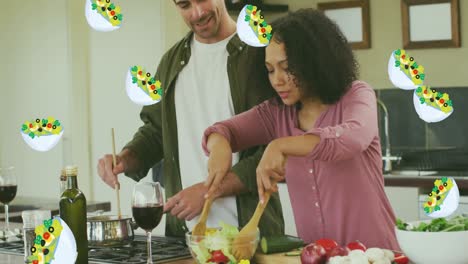 Animation-of-salad-icons-over-happy-diverse-couple-cooking