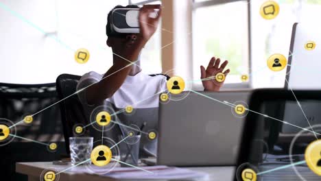 Animation-of-network-of-connections-with-icons-over-african-american-businessman-using-vr-headset