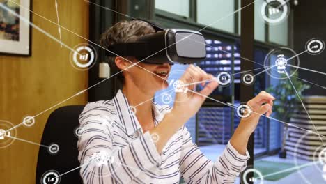 Animation-of-network-of-connections-with-icons-over-caucasian-businesswoman-using-vr-headset