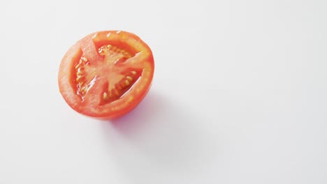 Video-of-fresh-halved-red-tomato-with-copy-space-on-white-background