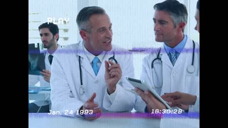 Animation-of-screen-with-glitch-over-male-doctors-using-tablet