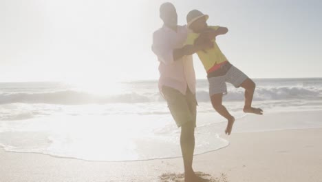 Lächelndes-älteres-Afroamerikanisches-Paar,-Das-Mit-Enkelkindern-Am-Sonnigen-Strand-Spielt