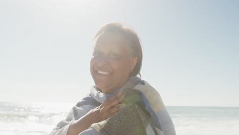 Portrait-of-smiling-senior-african-american-woman-on-sunny-beach