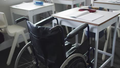 Video-Eines-Leeren-Rollstuhls,-Der-Am-Schreibtisch-Im-Klassenzimmer-Steht