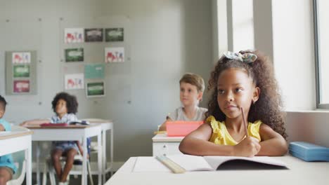 Video-Eines-Afroamerikanischen-Mädchens,-Das-Während-Des-Unterrichts-Im-Klassenzimmer-Am-Schreibtisch-Sitzt