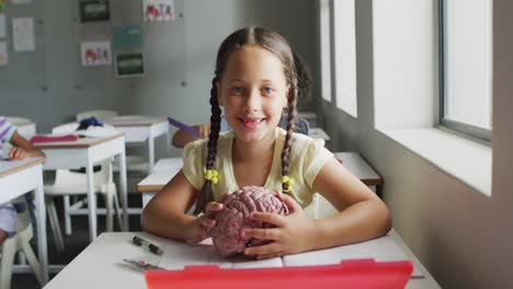 Video-Oh-Glückliches-Kaukasisches-Mädchen,-Das-Während-Des-Biologieunterrichts-Ein-Gehirnmodell-Hält