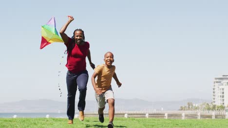 Video-of-happy-african-american-father-and-son-running,-having-fun-with-kite-outdoors