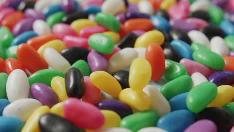 Video-Einer-Nahaufnahme-Von-Mehrfarbigen-Süßigkeiten,-Die-Auf-Einen-Blauen-Hintergrund-Fallen
