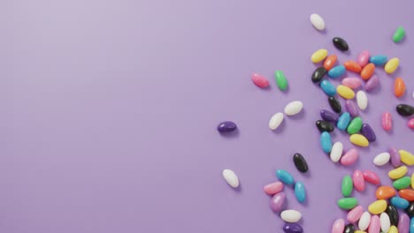 Video-Der-Draufsicht-Auf-Mehrfarbige-Süßigkeiten-Mit-Kopierraum-Auf-Violettem-Hintergrund
