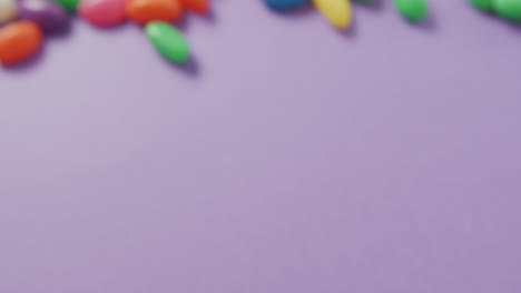 Video-Einer-Nahaufnahme-Von-Mehrfarbigen-Süßigkeiten-Mit-Kopierraum-Auf-Violettem-Hintergrund
