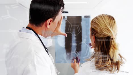 Animation-of-formulas-and-data-processing-over-caucasian-female-and-male-doctors-with-xray-photo