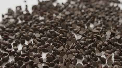 Video-of-close-up-of-multiple-chocolate-chip-over-white-background