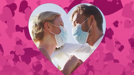 Animation-of-hearts-over-married-caucasian-couple-with-face-masks