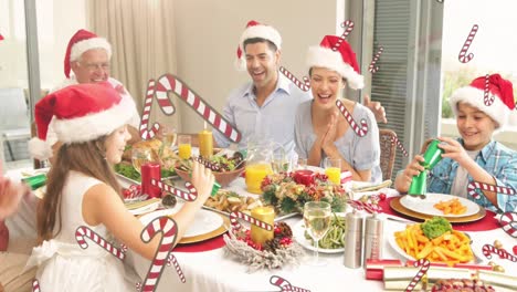 Animation-of-candy-canes-over-happy-caucasian-family-having-dinner