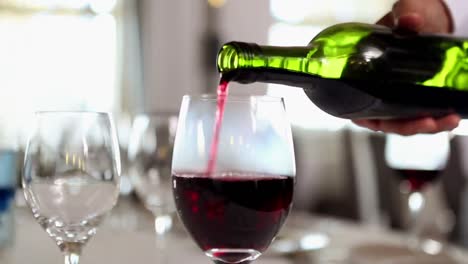 Waiter-pouring-a-bottle-of-red-wine