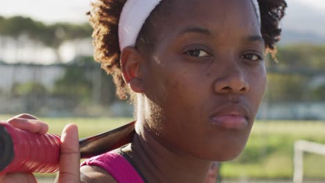 Video-Einer-Afroamerikanischen-Tennisspielerin,-Die-Einen-Schläger-Hält-Und-In-Die-Kamera-Blickt