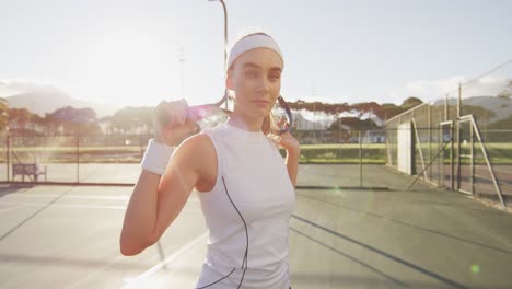 Video-Einer-Kaukasischen-Tennisspielerin,-Die-Einen-Schläger-Hält-Und-In-Die-Kamera-Blickt