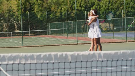 Video-Von-Glücklichen,-Vielfältigen-Tennisspielerinnen,-Die-Schläger-Halten-Und-Sich-Umarmen