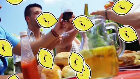 Animation-Von-Zitronensymbolen-über-Verschiedenen-Freunden-Am-Tisch-Mit-Getränken