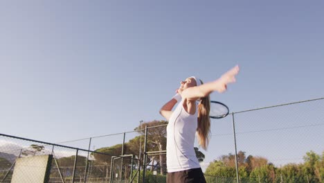 Video-of-happy-caucasian-female-tennis-player-holding-racket-and-hitting-ball