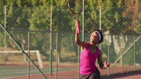 Video-Einer-Fokussierten-Afroamerikanischen-Tennisspielerin,-Die-Einen-Schläger-Hält-Und-Den-Ball-Schlägt