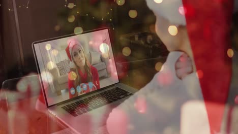 Animation-of-christmas-tree-over-happy-caucasian-woman-making-video-call