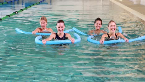 Four-women-doing-aqua-aerobics-smiling-at-camera