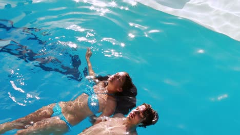 Couple-floating-in-the-swimming-pool