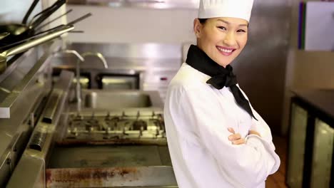Happy-chef-smiling-at-camera-beside-the-stove