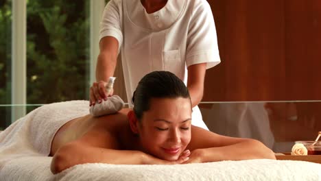 Gorgeous-woman-getting-a-massage-with-herbal-compresses