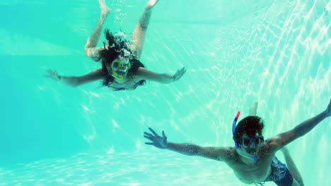 Una-Pareja-Feliz-Saltando-Juntos-En-La-Piscina-Usando-Snorkels