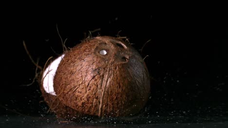 Kokosnuss-Fällt-Und-Spaltet-Sich-Auf-Schwarzem-Hintergrund