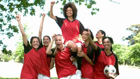 Female-football-team-celebrating-a-win-in-the-park