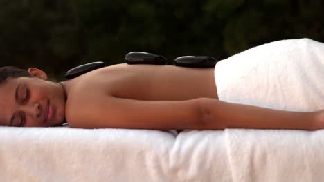 Calm-brunette-enjoying-a-hot-stone-massage-