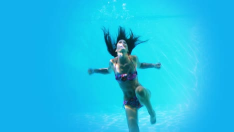 Pretty-brunette-swimming-underwater-in-pool