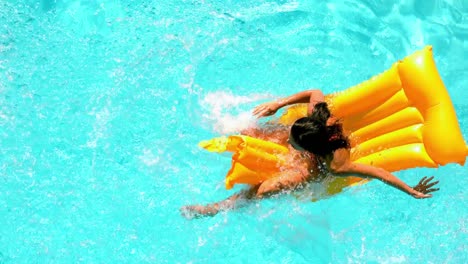Brunette-splashing-on-lilo-in-the-swimming-pool