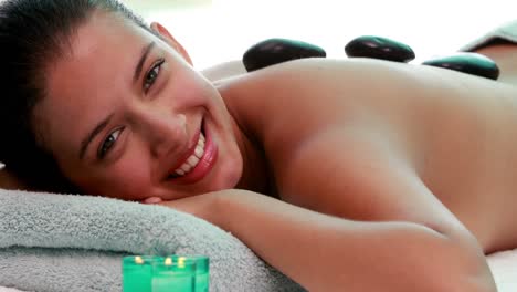 Calm-brunette-getting-hot-stone-massage