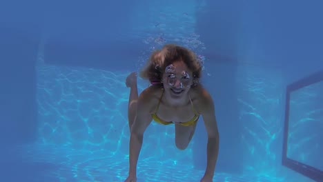 Hübsche-Blondine-Schwimmt-In-Richtung-Kamera-Und-Winkt