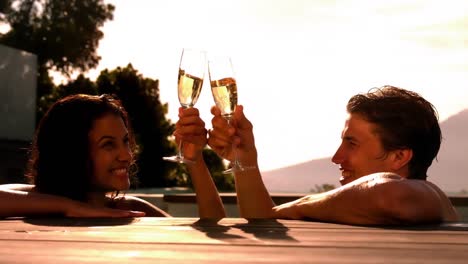 Glückliches-Paar-Trinkt-Gemeinsam-Champagner-Im-Schwimmbad
