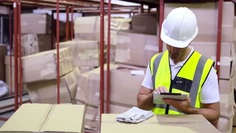 Warehouse-worker-checking-boxes-for-shipping-with-tablet-pc
