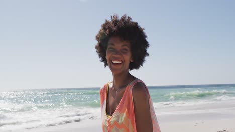 Porträt-Einer-Lächelnden-Afroamerikanischen-Frau,-Die-Am-Sonnigen-Strand-In-Die-Kamera-Blickt