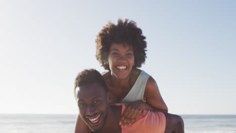 Porträt-Eines-Lächelnden-Afroamerikanischen-Paares,-Das-Sich-Am-Sonnigen-Strand-Umarmt