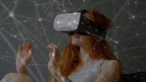 Animation-of-network-of-connections-over-caucasian-woman-using-vr-headset