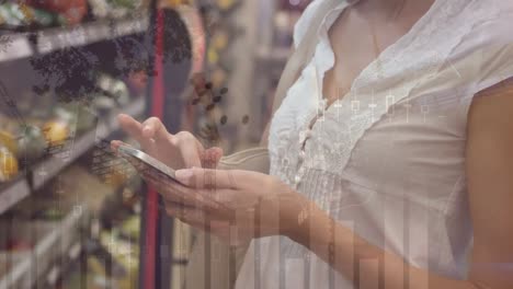 Animation-of-financial-data-over-hands-of-caucasian-woman-using-smartphone-and-shopping-at-market