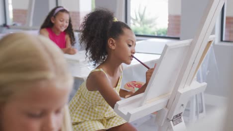 Video-of-focused-diverse-girls-painting-during-art-lessons-at-school
