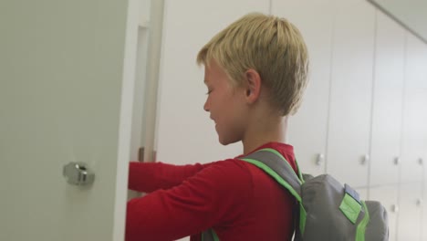 Video-Eines-Kaukasischen-Jungen,-Der-Den-Spind-Schließt-Und-In-Der-Schule-Lächelt
